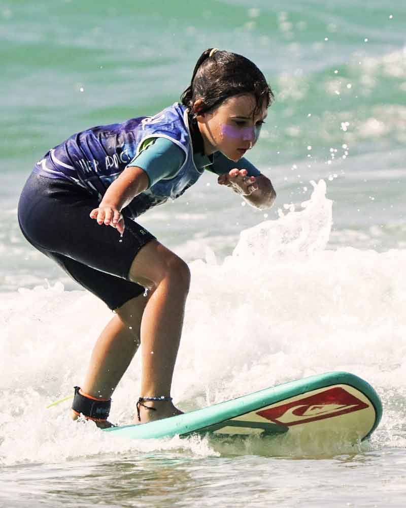 fillette sur une petite vague en planche en mousse cours de surf enfant capbreton