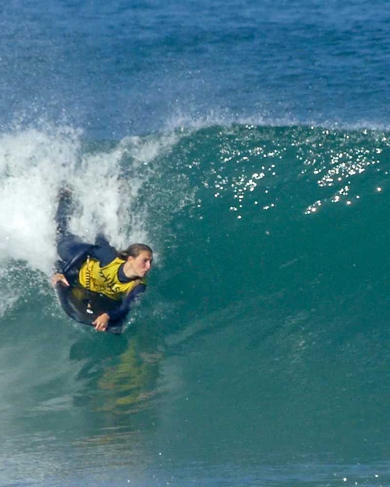 fille en bodyboard niveau compétition sur une belle vague eau bleu 