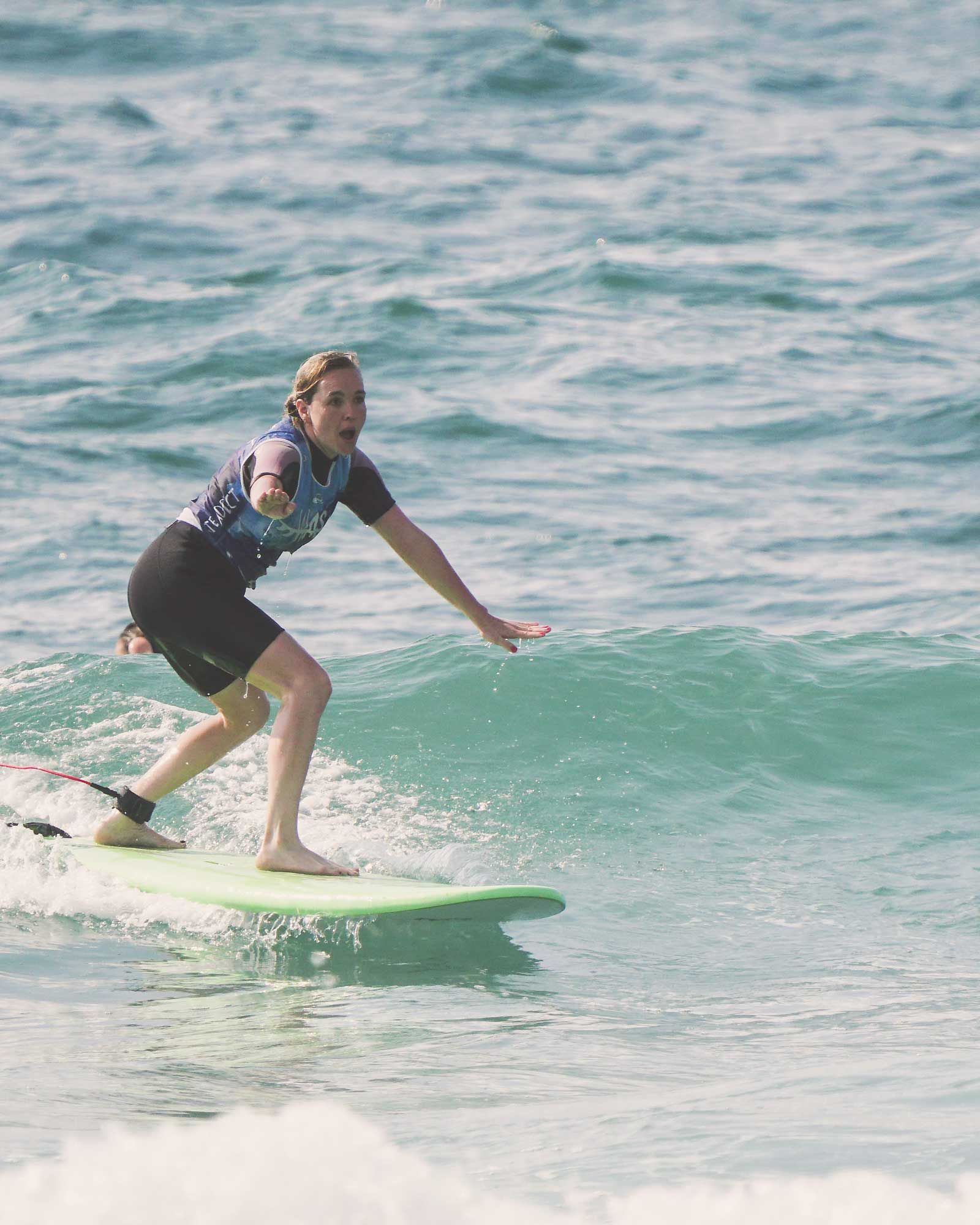 surfeuse sur une petite vague pendant un cours de surf qui permet d'apprendre le surf à Capbreton