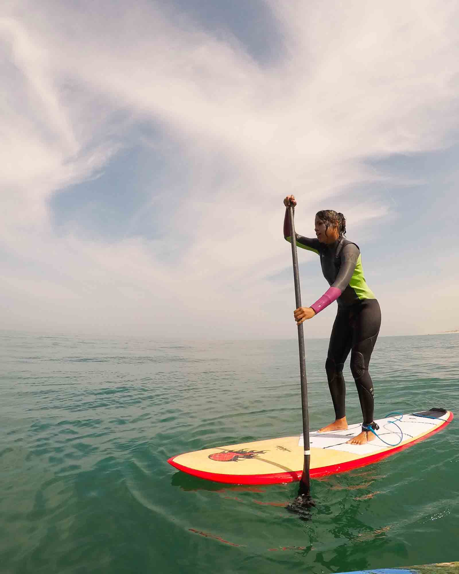 femme ramant sur son stand up paddle sur l'ocean au large